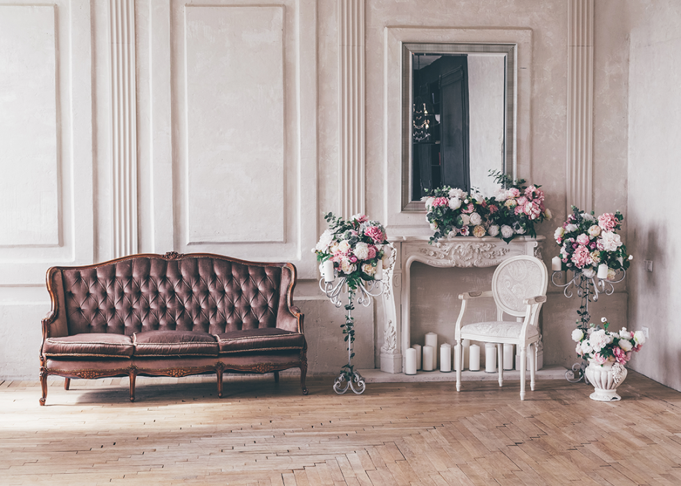 A vintage interior sofa with a vase of flowers in a shabby chic style.