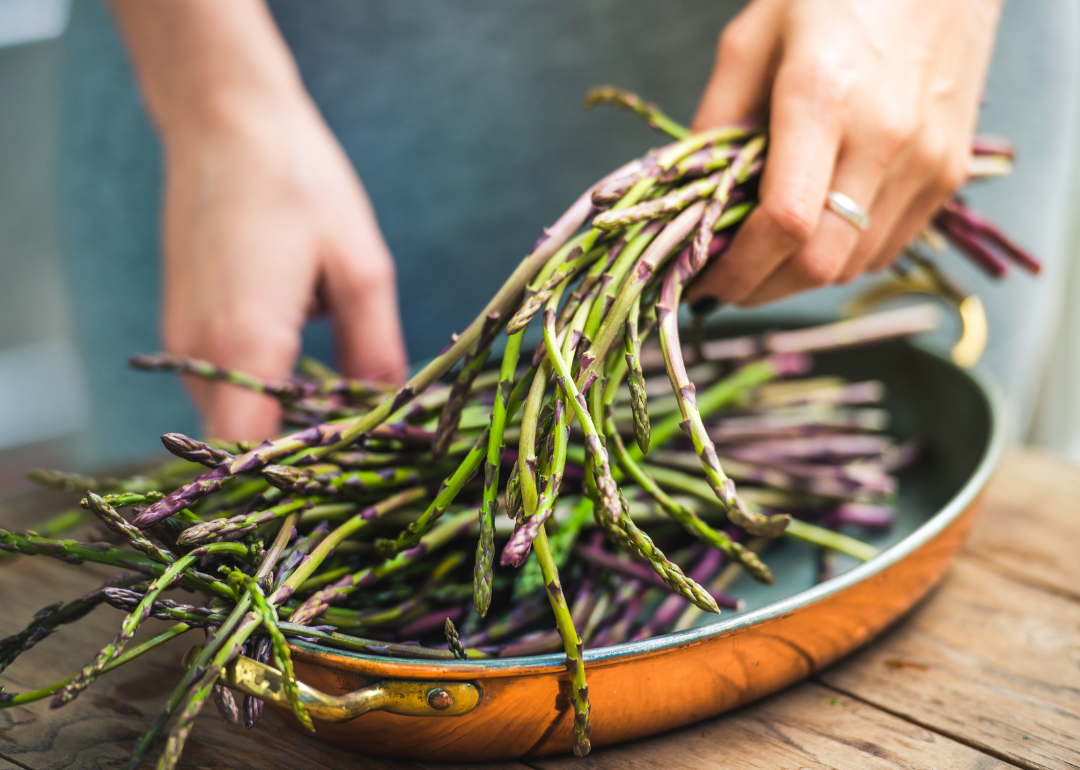 Person preparing fresh asparagus.