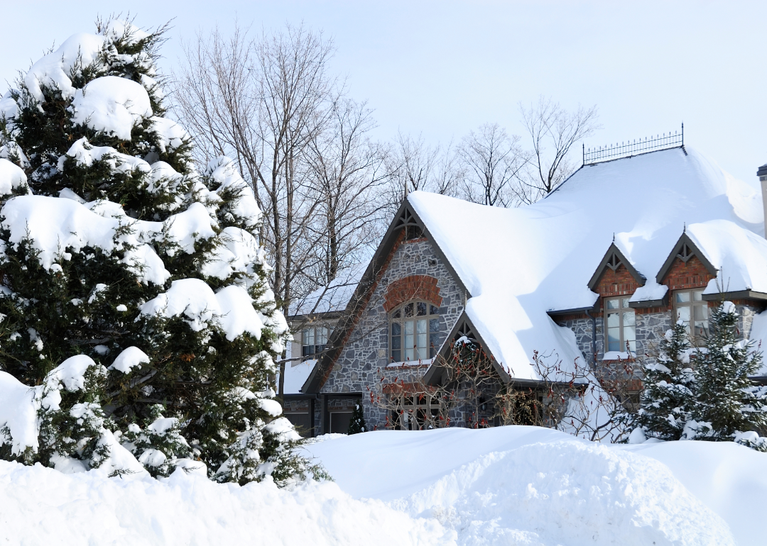 A log cabin in a wooded area covered with snow.