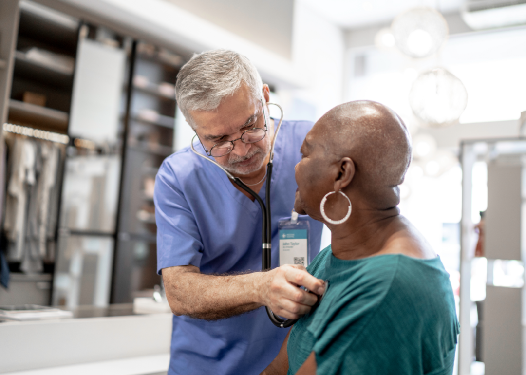A doctor tends to an older patient.
