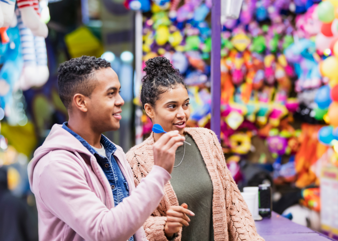 A young couple enjoying themselves at a street fair.