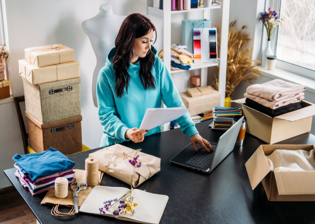 A small business owner looks at her laptop with concern.