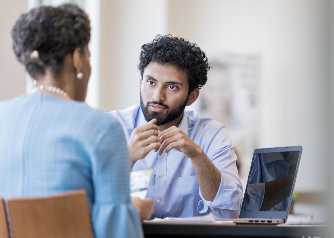 Two people have a serious discussion in an office.