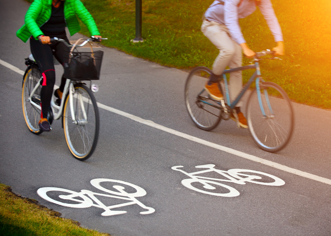 Two cyclists riding on a bike path. 