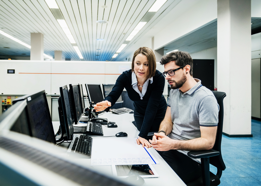 Two colleagues working at an office computer.