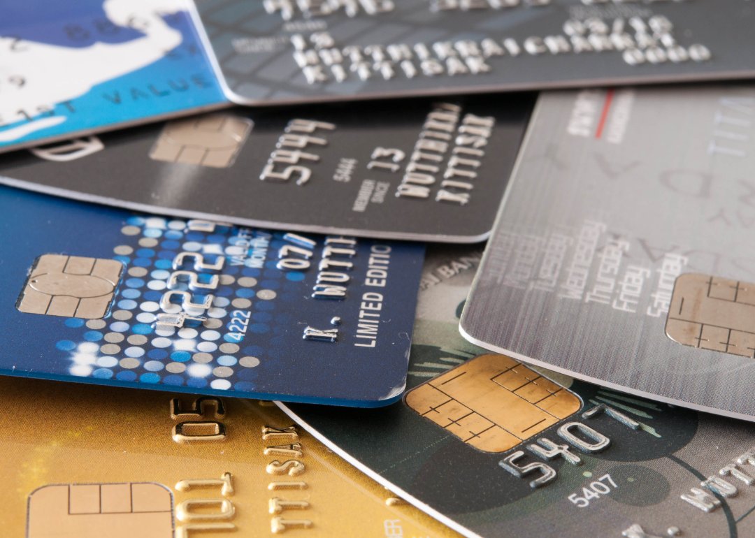 A pile of credit cards resting on a wooden surface.