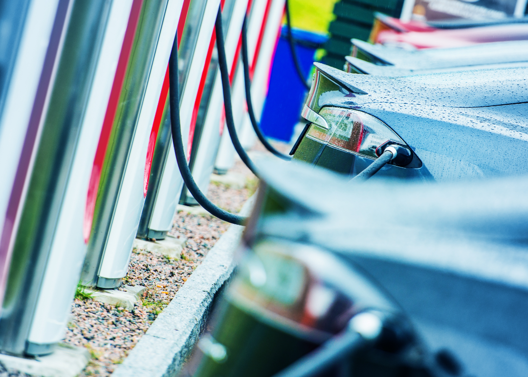 Electric vehicles charging at a charging station.