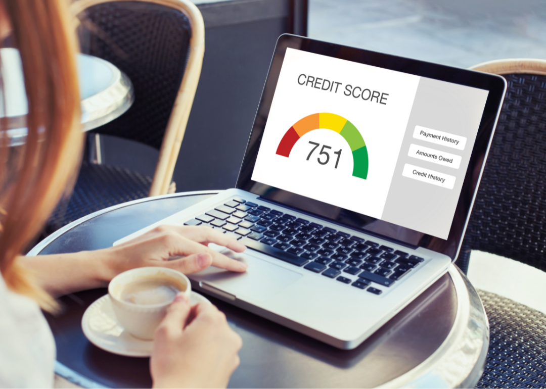 A laptop displays a credit score of 751.