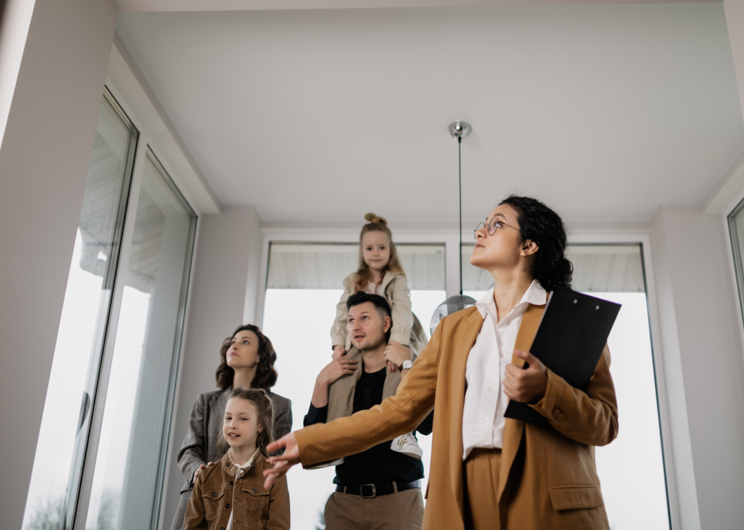 A real estate agent shows a family a home.