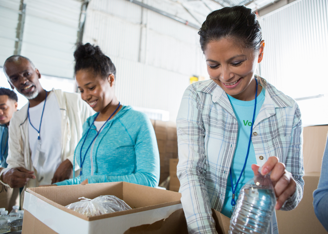 Three people help pack food at a food pantry.
