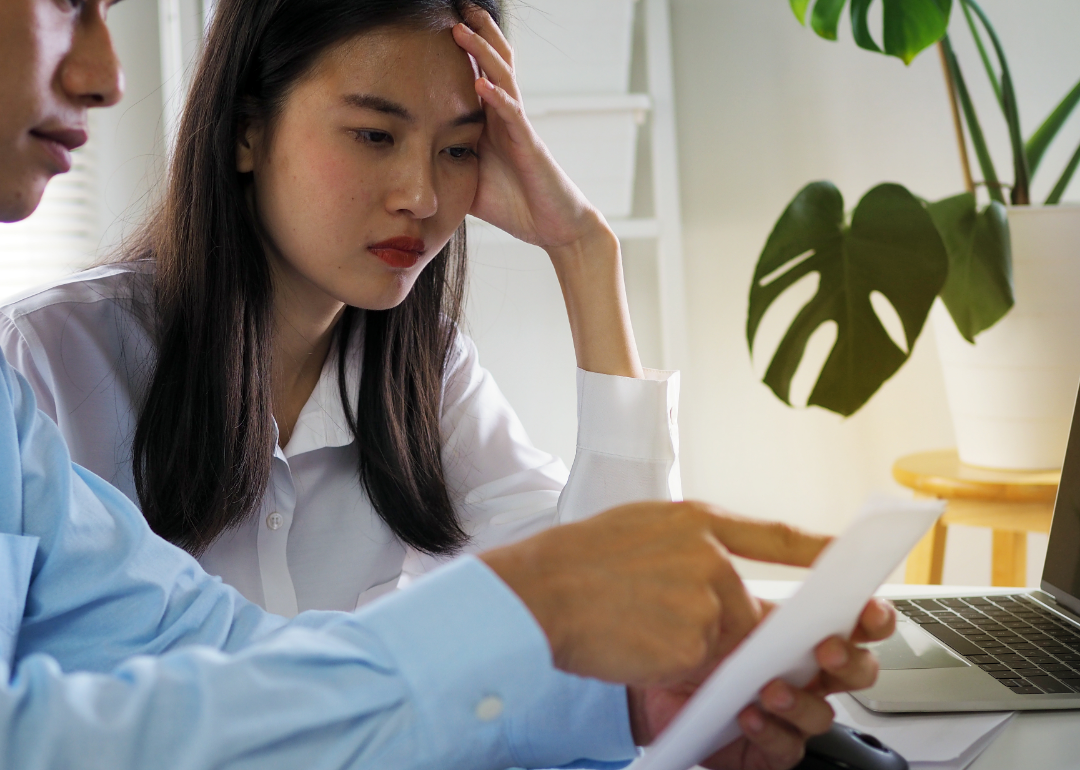A couple looks concerned as they review their finances.