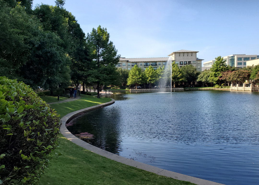 Tree-lined walking path near a lake in Frisco, Texas.
