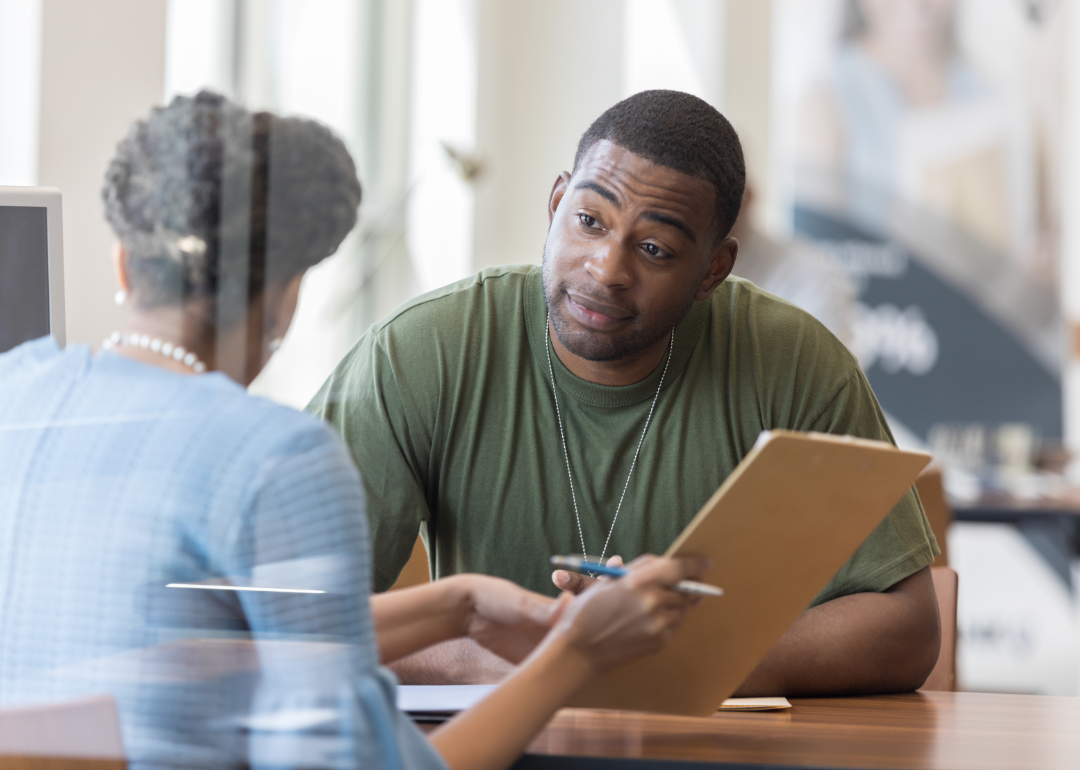 A loan officer discusses financing with a soldier.