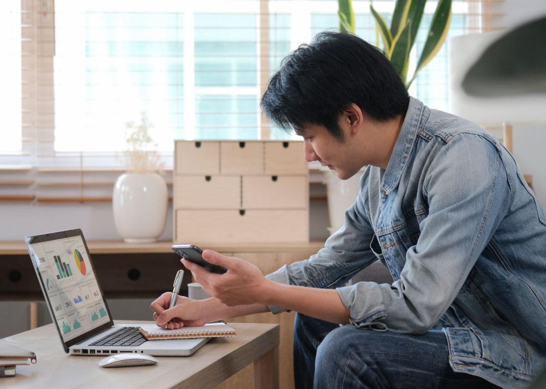 A millennial man searching information online, working with computer laptop.