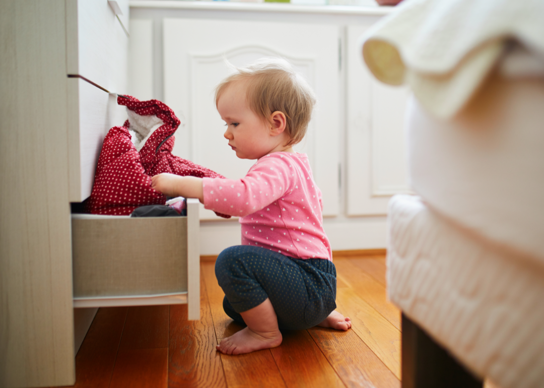 Baby rummaging through bottom drawer.