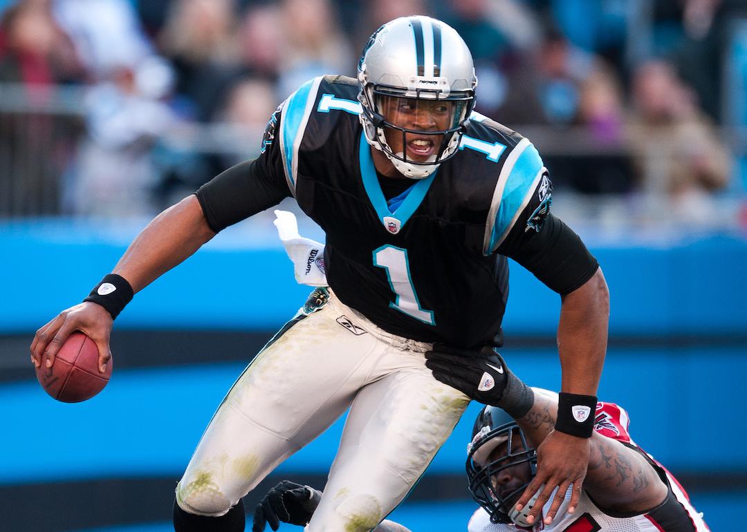 Quarterback Cam Newton #1 of the Carolina Panthers scrambles away from the rush by John Abraham #55 of the Atlanta Falcons.