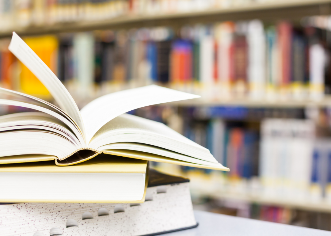 A stack of textbooks with an open one on top.