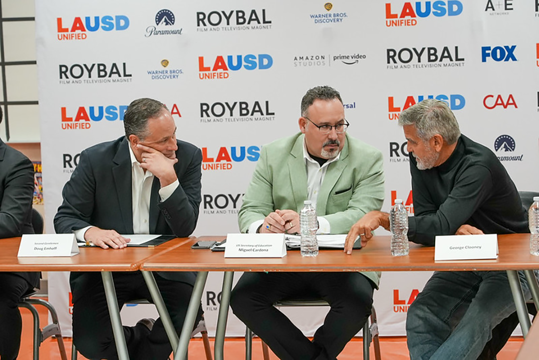 Three people sit at a table.