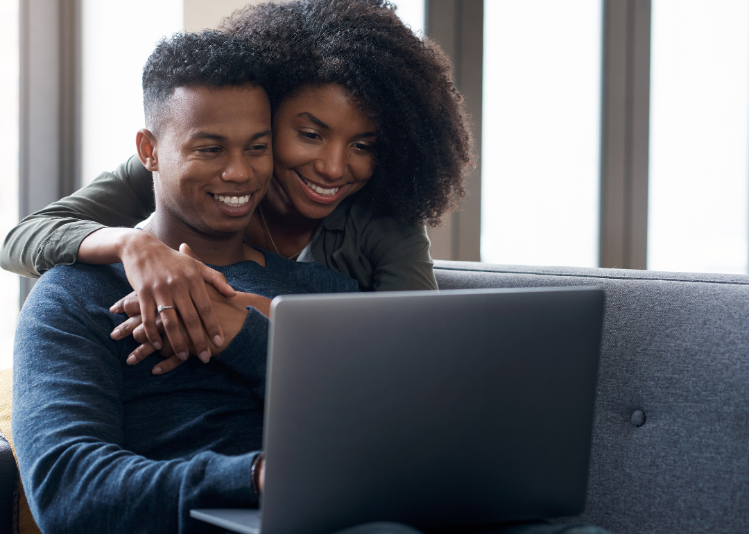 A couple checking their credit score on a laptop computer.