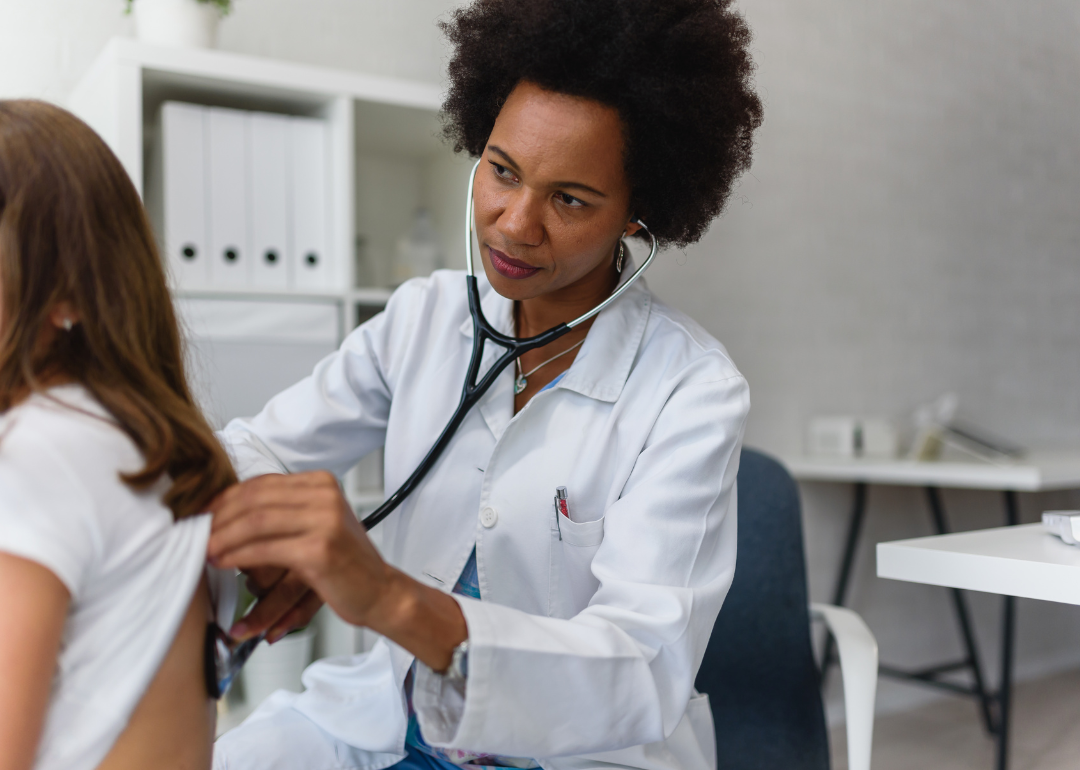 Woman doctor using stethoscope on patient for respiratory illnesses.