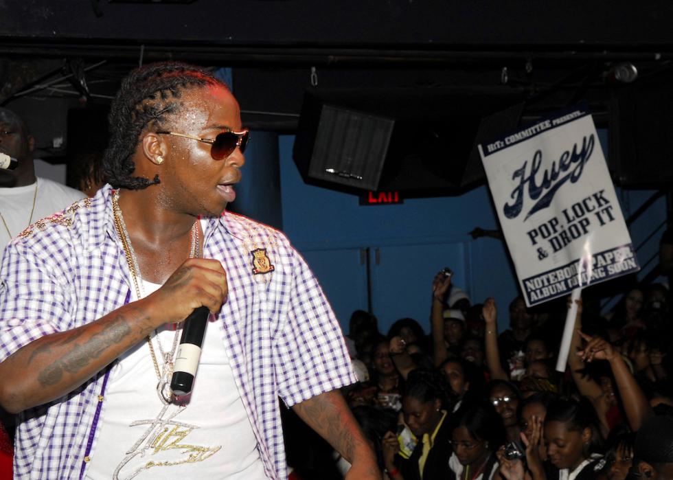 Rapper Huey performing onstage at concert.