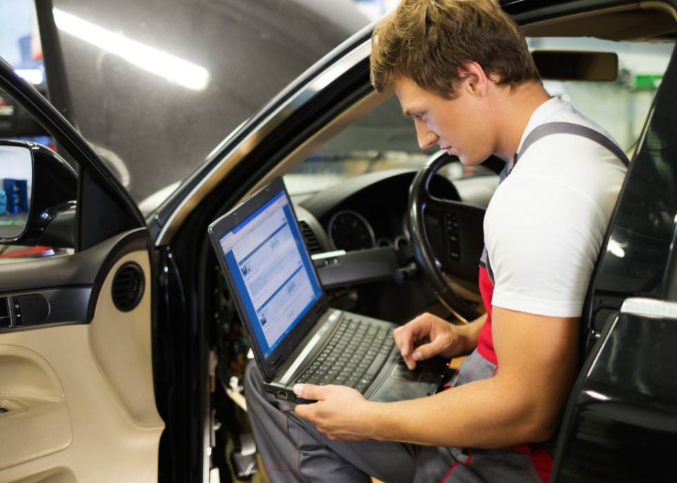 A technician runs diagnostics on an electric vehicle