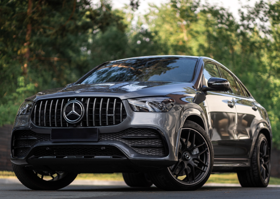 A silver Mercedes-Benz GLE Coupe AMG 53 4Matic+ 2023 parked on the forest on a warm summer day