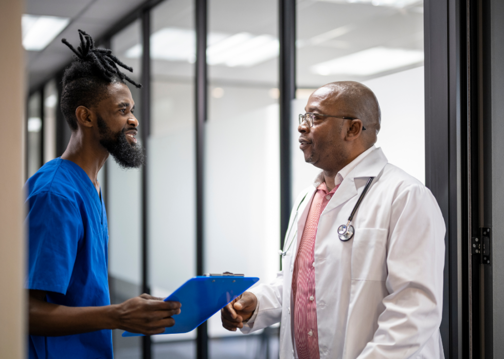 A young nurse speaks with an older doctor.
