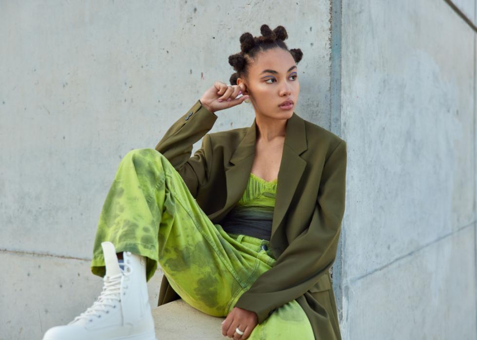 Stylish woman seated in a green outfit.