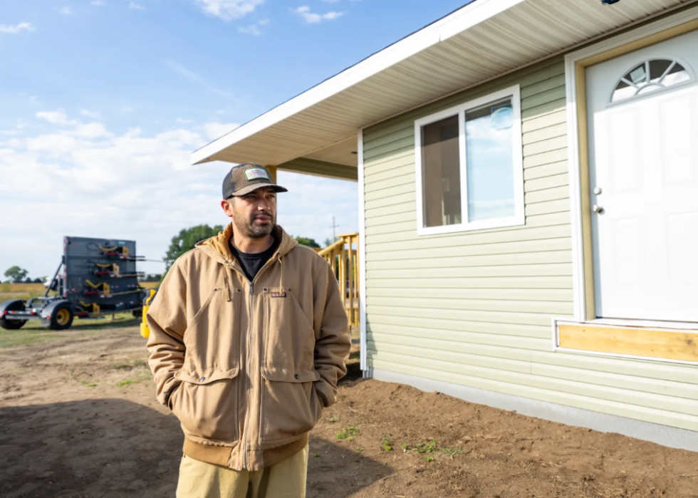 Danny Desjarlais stands next to a newly built duplex 