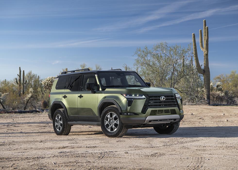 Green Lexus GX parked in desert with Saguaro cactus in background.