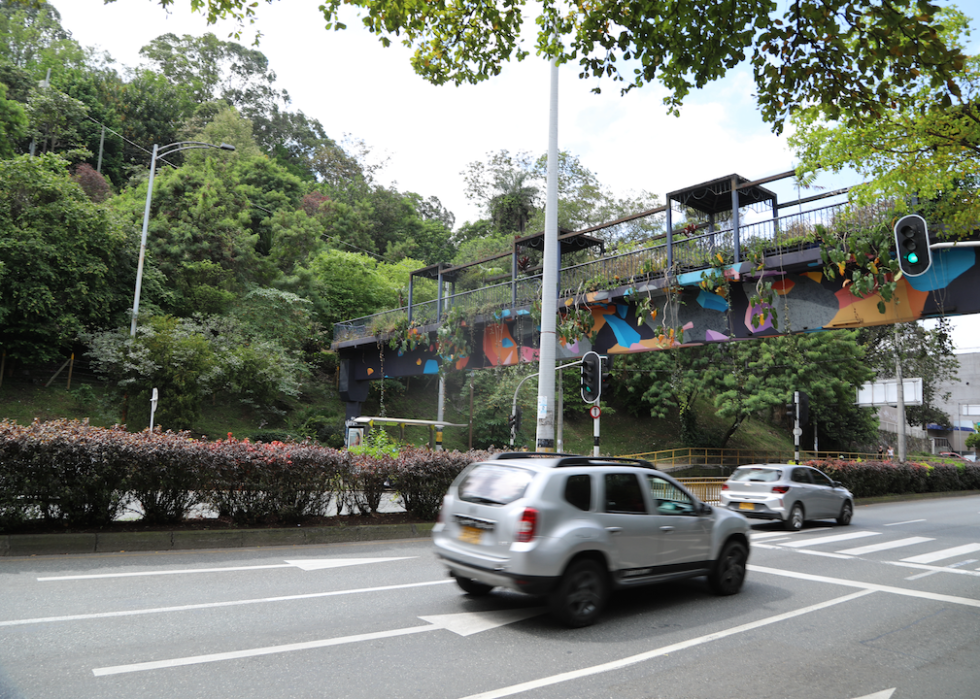 cars driving on the road in medellin, colombia near trees and plants
