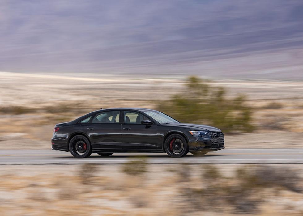 A black Audi S8 being driven on a road.