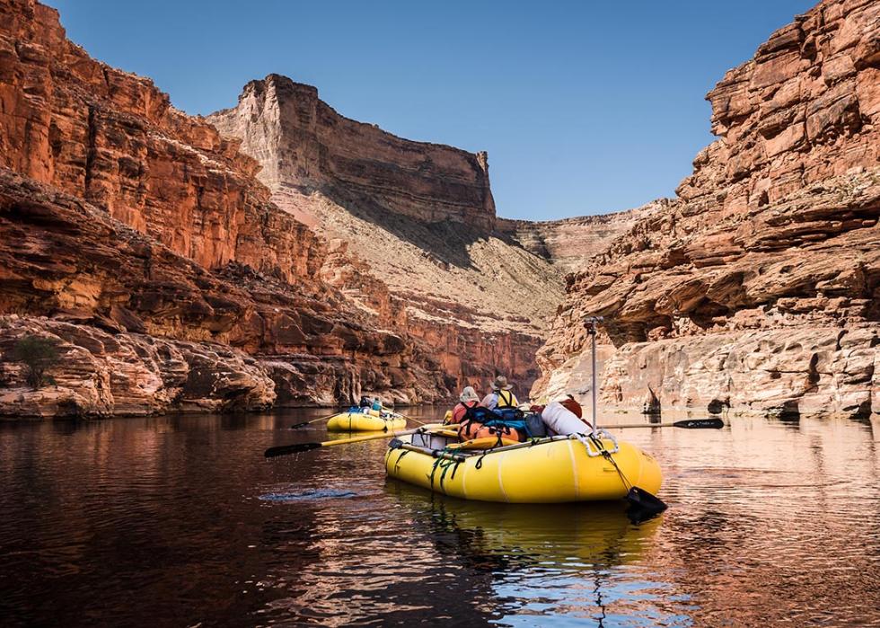 Whitewater Rafting on the Colorado River in Grand Canyon National Park, surrounded by red cliffs.