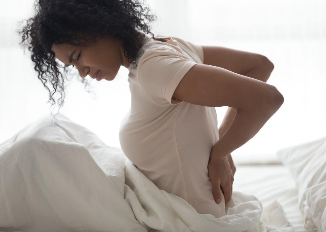 Woman waking up with body pain.