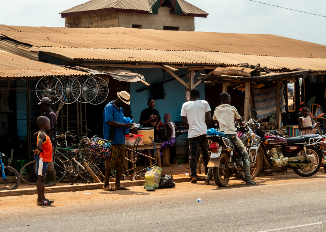 People standing in front of shops by roadside