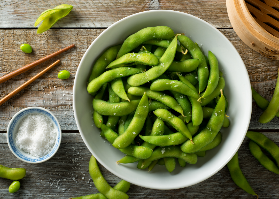 Bowl of edamame with chopsticks.
