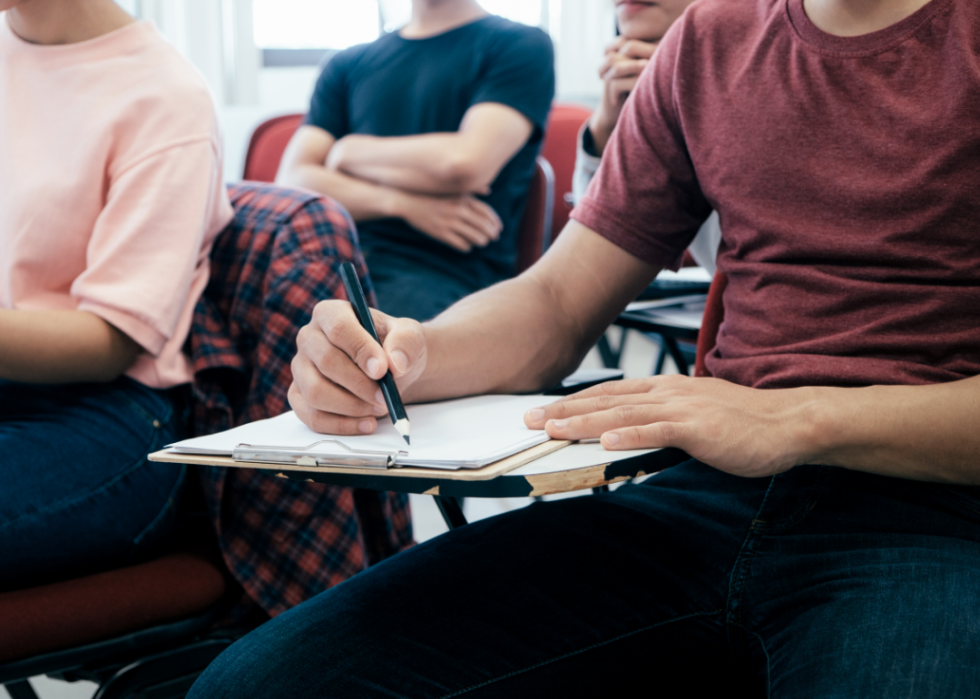 Male student writing at desk