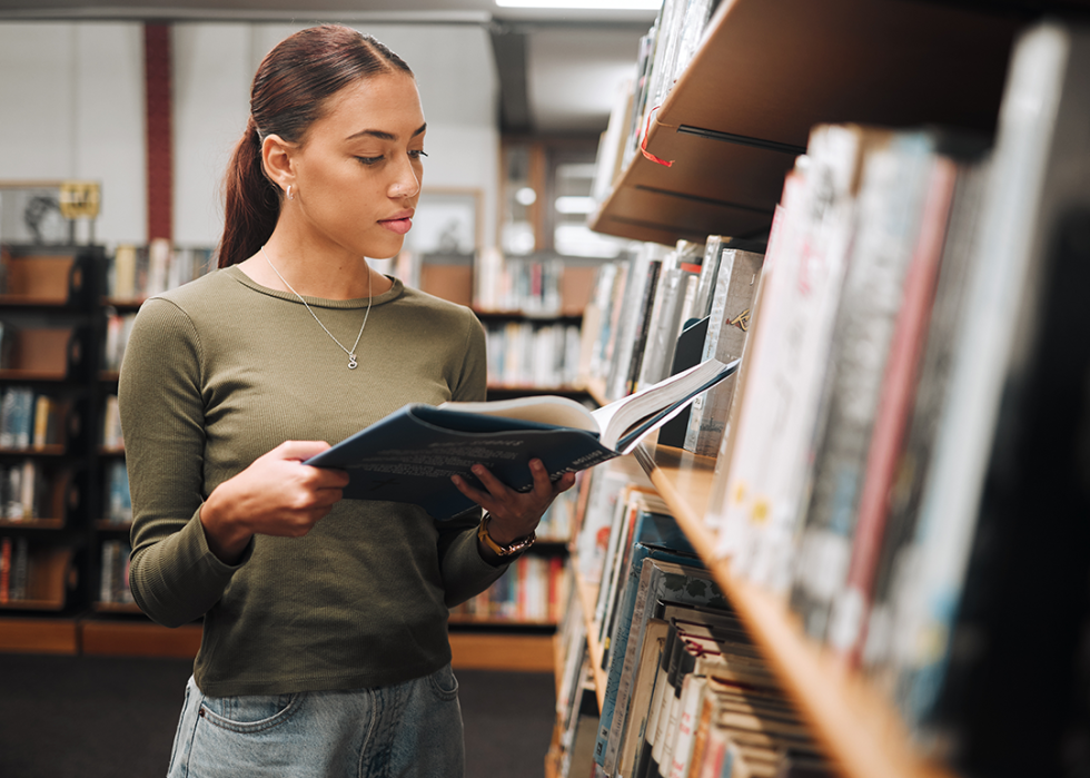 Student looking at book in library.