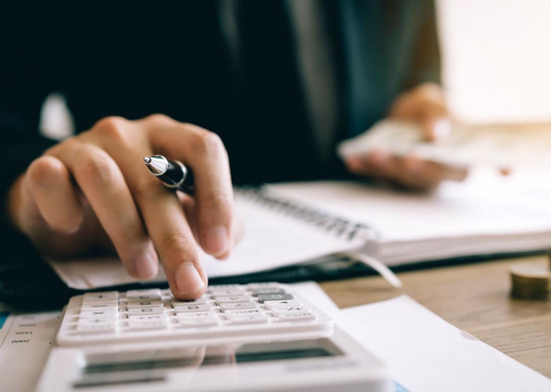 Person using calculator taking notes.