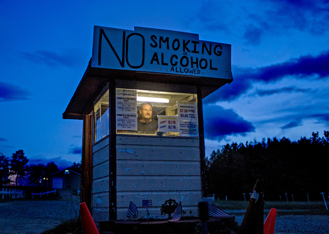 The owner of the Bridgton Twin Drive-In waits for patrons at the front gate.