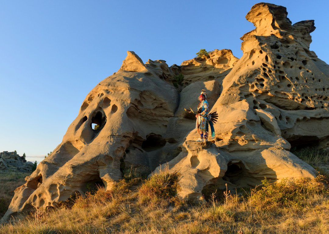 Native American poses in front of Medicine Rocks