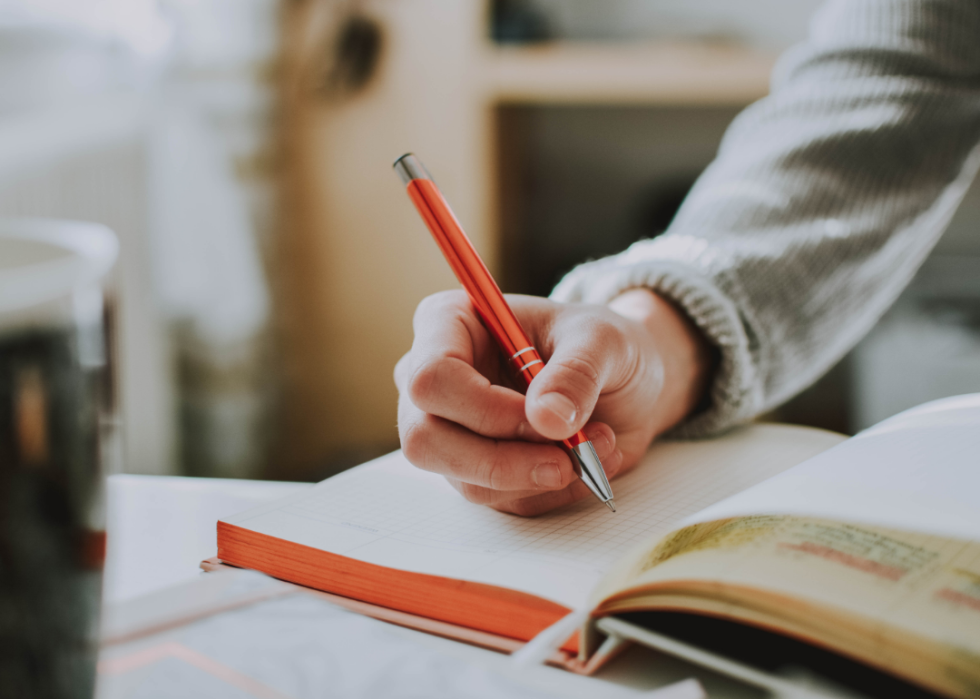 Closeup of hand writing in notebook