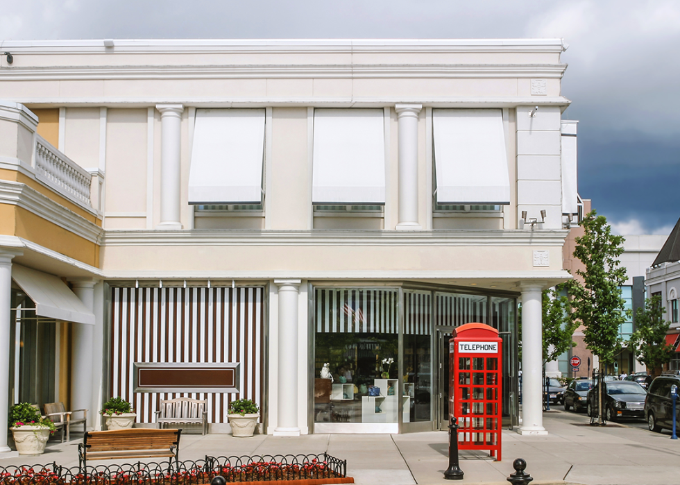 Red telephone box in front of downtown shops.