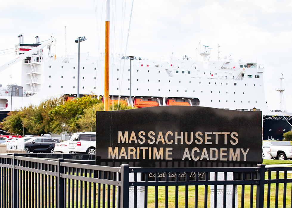 Massachusetts Maritime Academy  sign with ship in background.