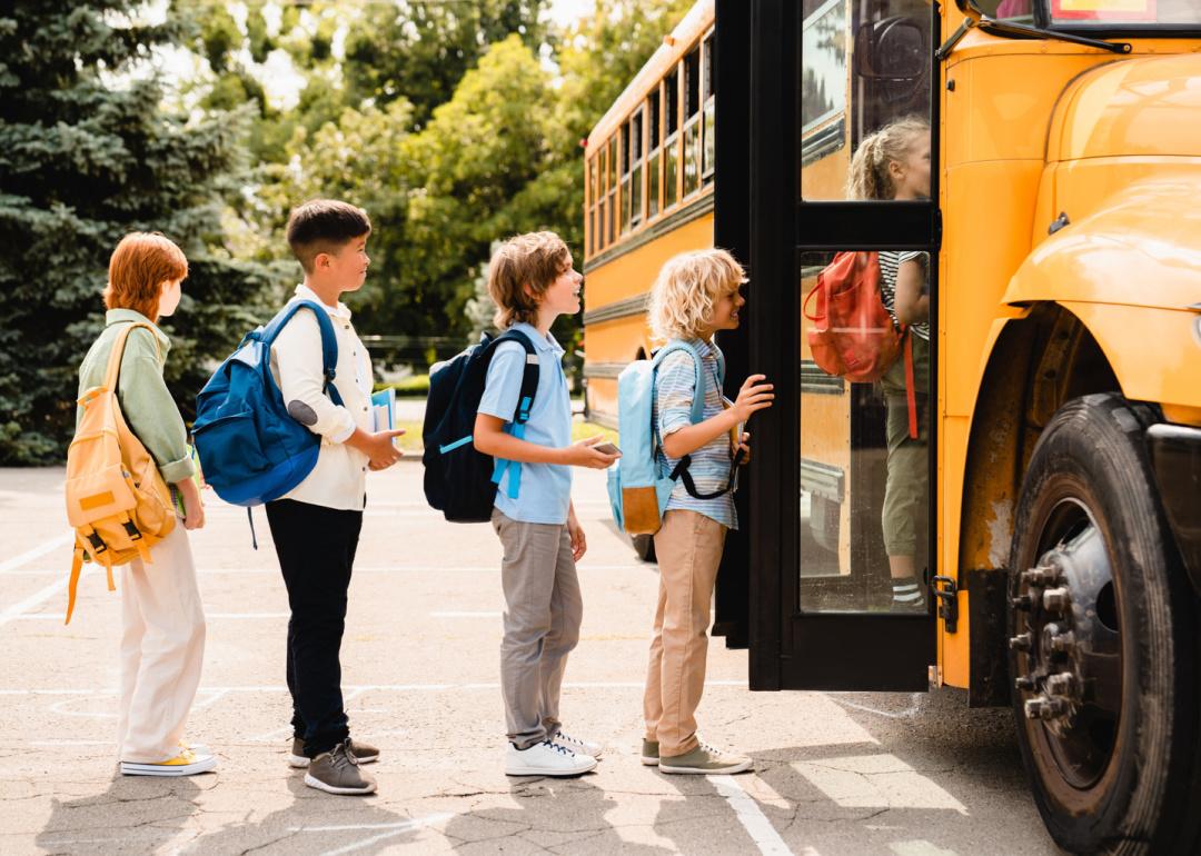 School children lined up to board bus.
