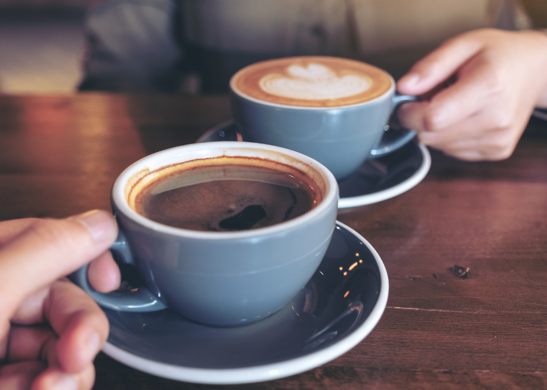 Two people drinking coffee in cafe.