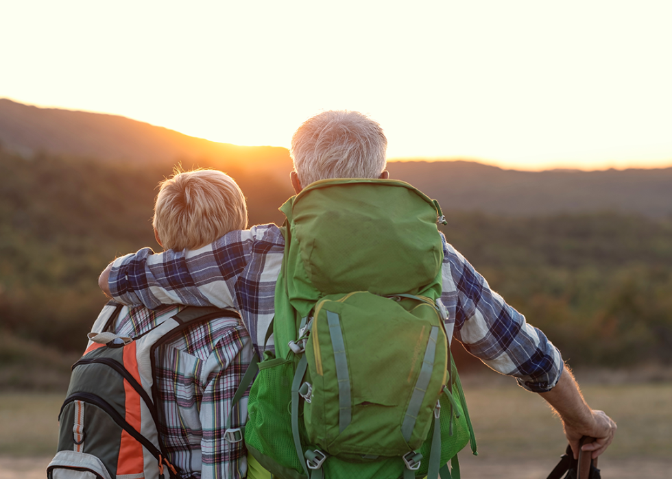Mature couple with packpacks looking at sunset.