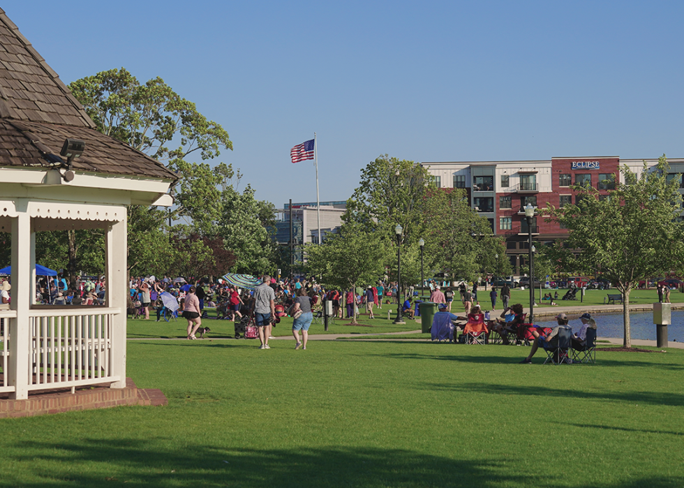 People gathering at a park with gazebo.