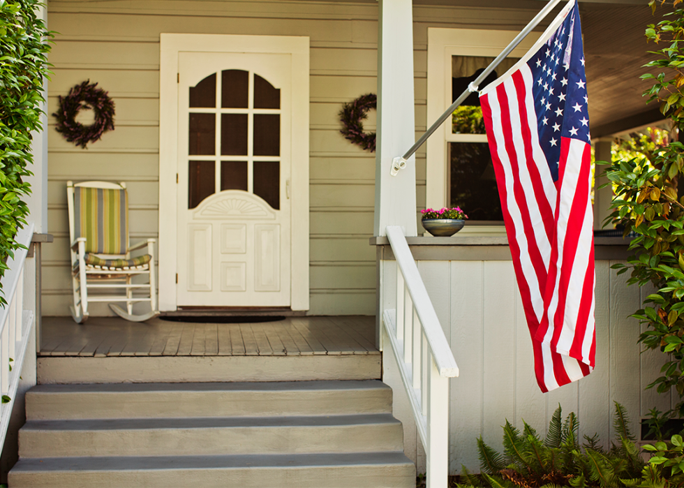 American flag on the porch of a suburban house.